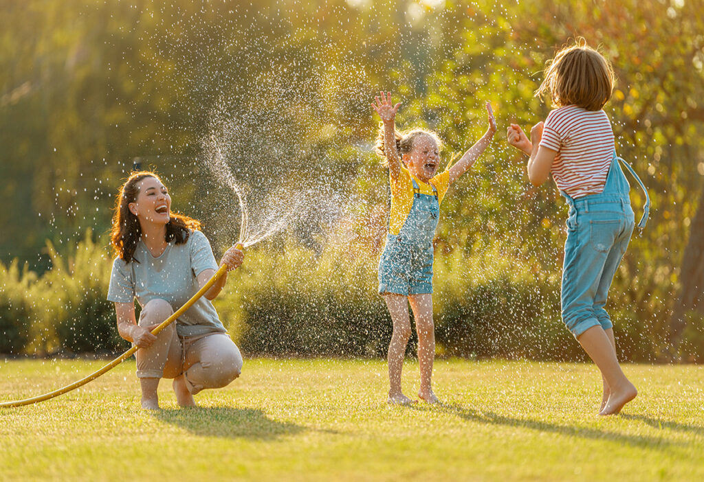 family playing in water on a lawn