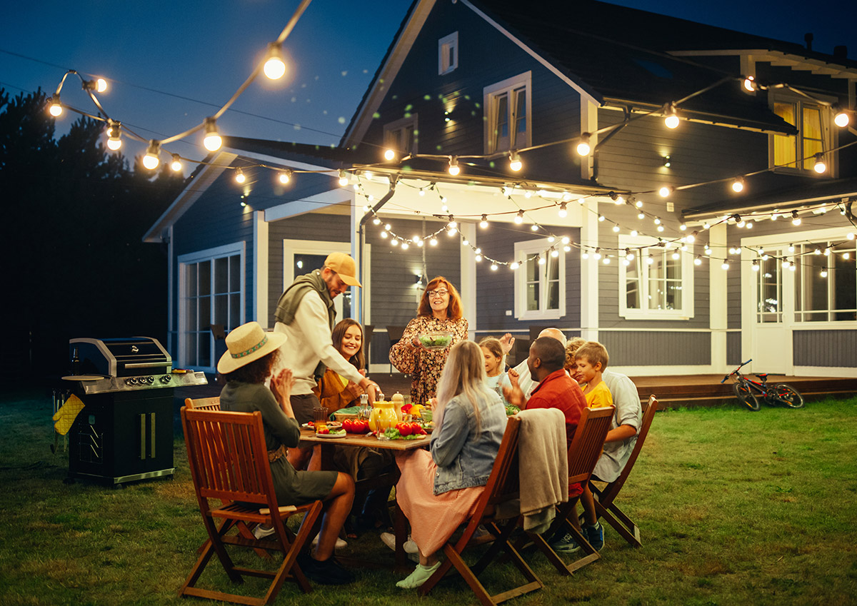 family and friends eating outside in backyard in the summer